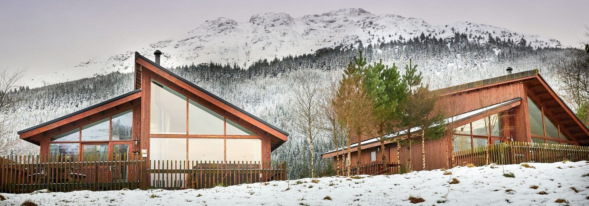 Log cabins in the snow at Forest Holidays, Scotland