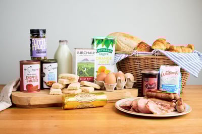 Deluxe welcome hamper products laid out on a wooden board