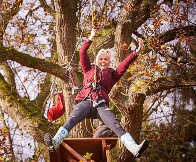 Girl zooming through the trees on Zipwire