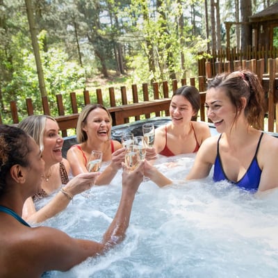 Female friends celebrating in the hot tub at Forest Holidays