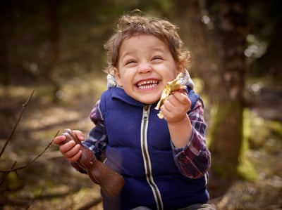 Boy eating chocolate in the forest