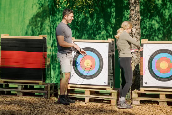 Two adults taking part in archery