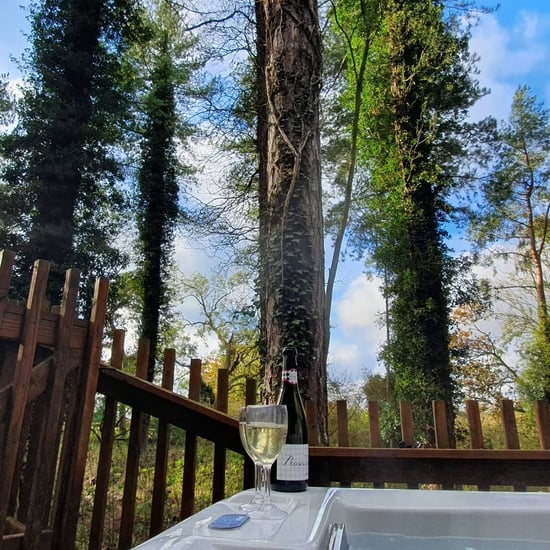 Hot tub view with a glass of prosecco by @kim.runs.a.marathon