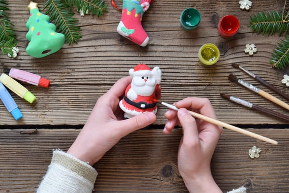 Aerial view of a person painting a Santa pottery item