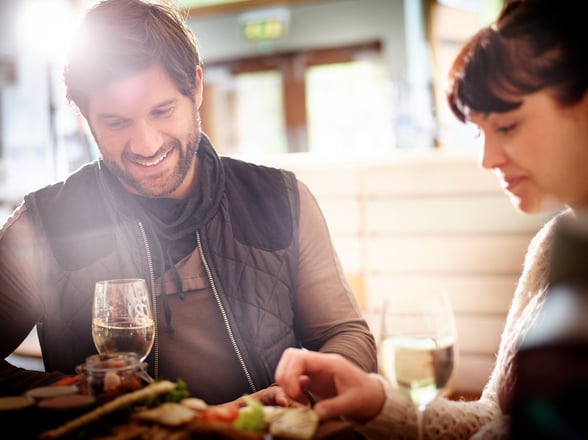A couple enjoying a meal with a glass of wine