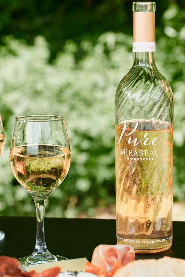 A bottle of pure Mirabeau rose and glass