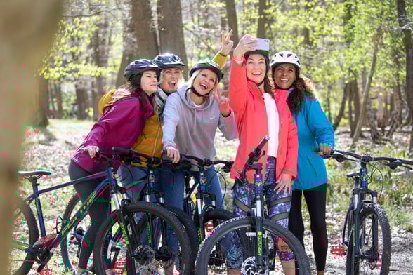 Group of friends take a selfie on a bike ride through the forest
