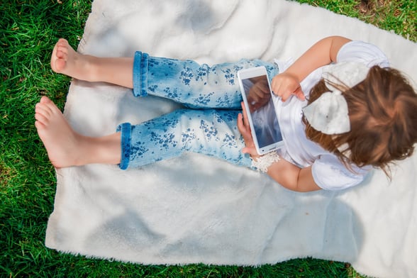 Child using an iPad in nature