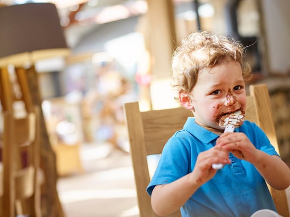 Young boy eating food at the Forest Retreat at Forest Holidays