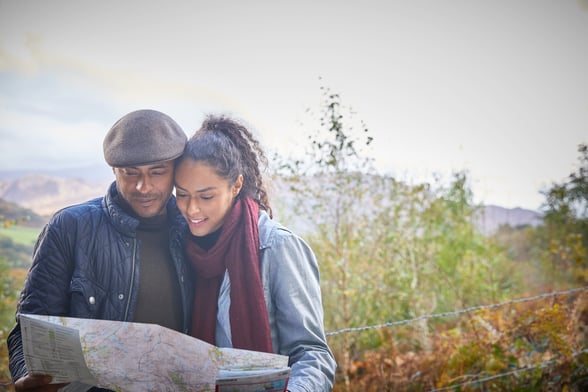 A couple walking through Delamere Forest with a map