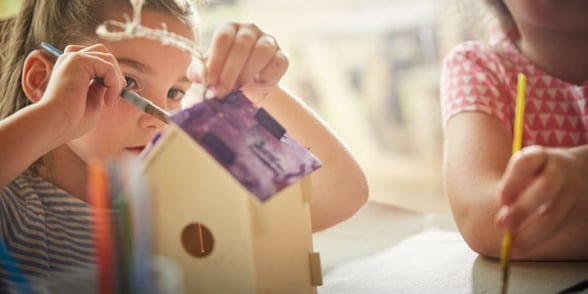 Children painting bird boxes in the Forest Retreat at Sherwood Forest, Forest Holidays