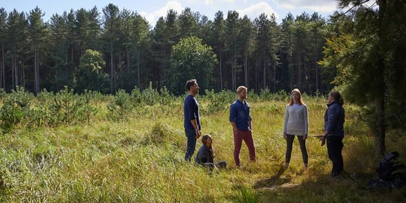 A group experiencing a Forest Bathing session with a Forest Holidays Forest Ranger guiding them through.