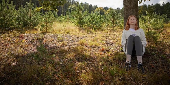 A woman at a sit spot during the Forest Bathing session at Forest Holidays
