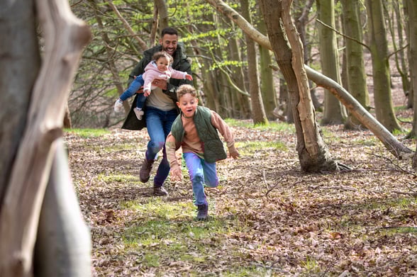 Family running through Autumn leaves