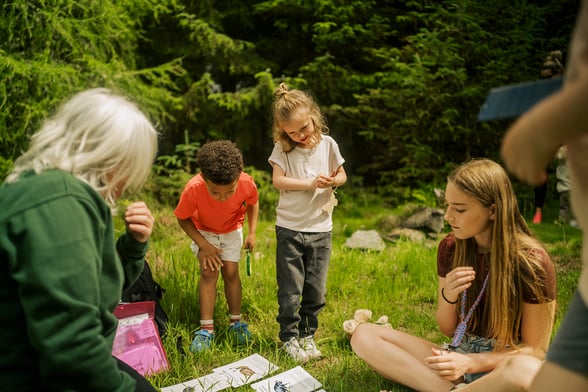 A forest ranger reading bug facts to children