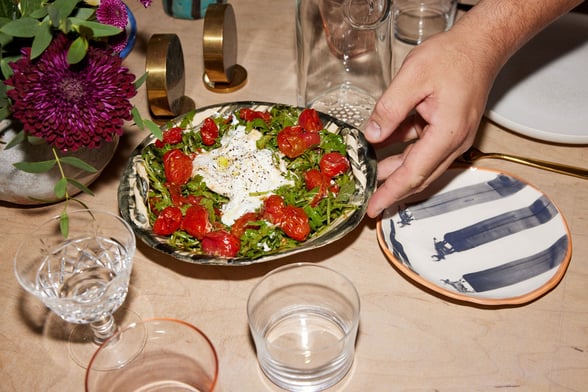 Close up of a bowl of tomatoes, mozzarella and salad leaves