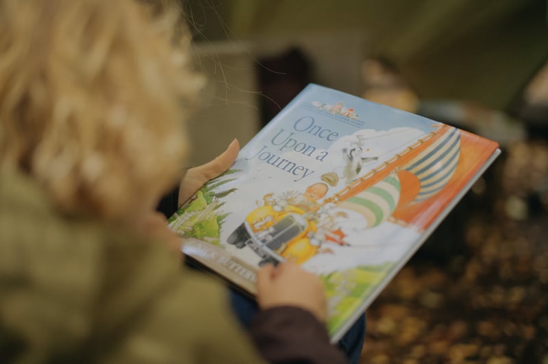 A child reading 'Once Upon a Journey' book