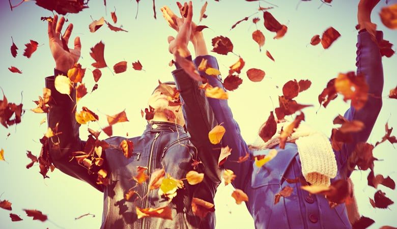Couple throwing leaves in the air
