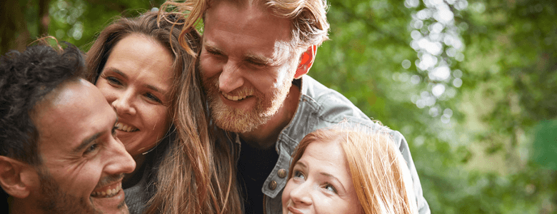 Group of friends huddle together in the forest