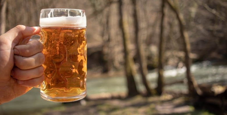 Holding a beer outdoors in the forest