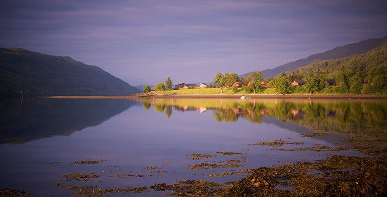 Lochside view of log cabins in Scotland