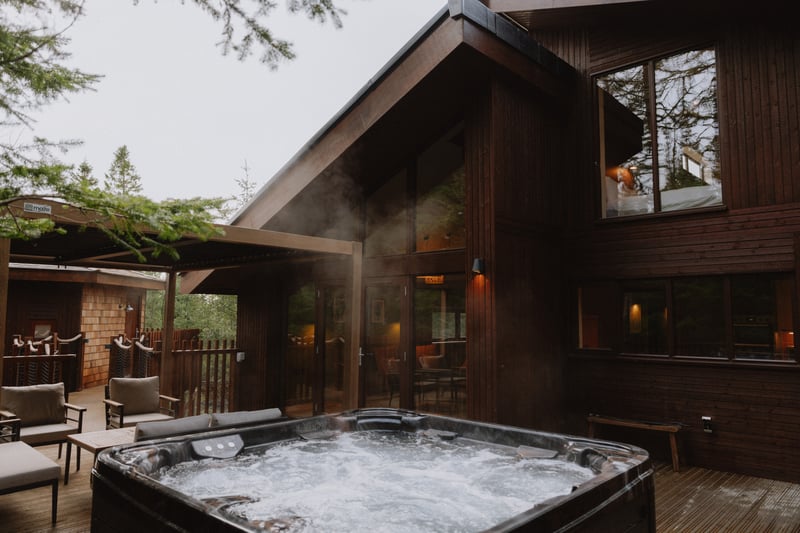 A hot tub outside a log cabin